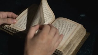 Birisi eski bir Slavonik kitabı karıştırıyor.