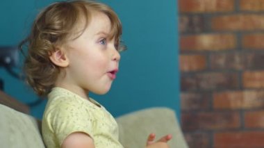 Küçük kız el sallıyor ve gülüyor