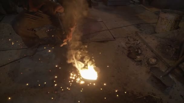 Рабочий выливает горячий металл — стоковое видео