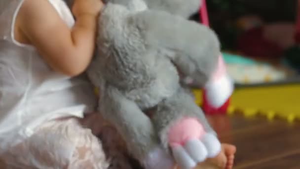 Красивая маленькая девочка играет с мягкой игрушкой — стоковое видео