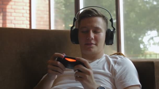 Egy férfi fejhallgatóval videojátékot játszik. — Stock videók