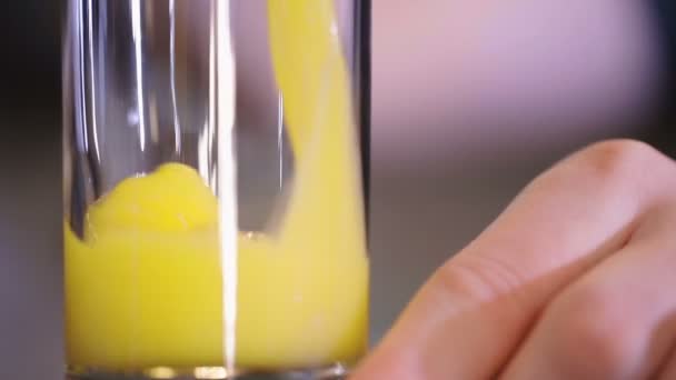Sinaasappelsap dat in glas stroomt — Stockvideo
