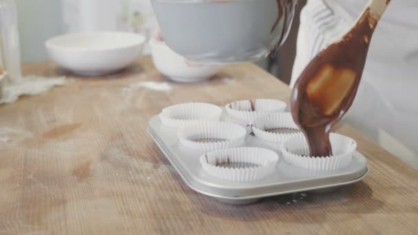 Шеф-кухар вставляє шоколадне тісто в паперові чашки — стокове відео