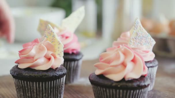 Mãos femininas decorando muffins de chocolate — Vídeo de Stock