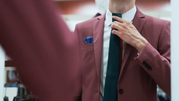 Masculino vestido no elegante vermelho terno escolhe seu gravata — Vídeo de Stock