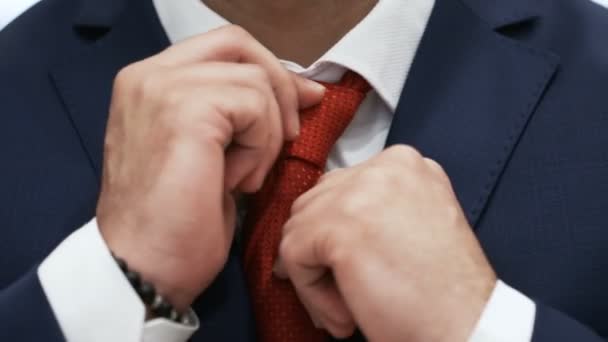 Empresário está corrigindo gravata vermelha em uma camisa branca — Vídeo de Stock