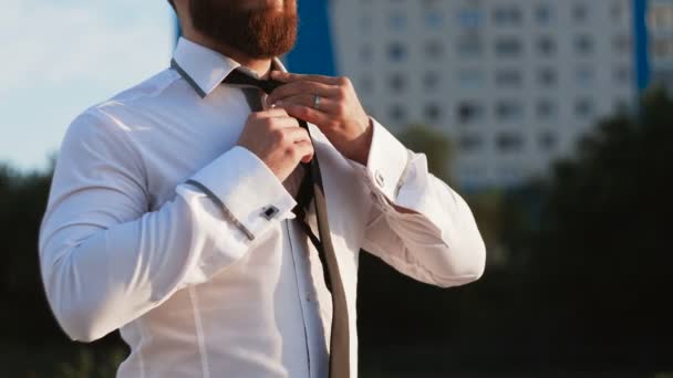 Beyaz gömlekli bir iş adamı dışarıda kravatı bağlıyor. — Stok video