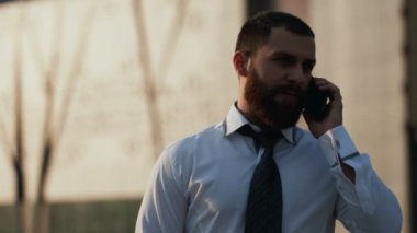 Akıllı telefon kullanan çekici beyaz iş adamı.