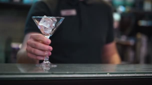 Professionele barman met glas met ijsblokjes — Stockvideo