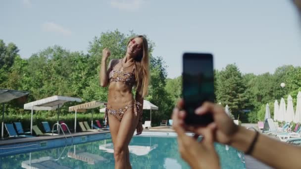 Chica con la prensa inflada en bikini posando para fotos en un teléfono móvil — Vídeos de Stock