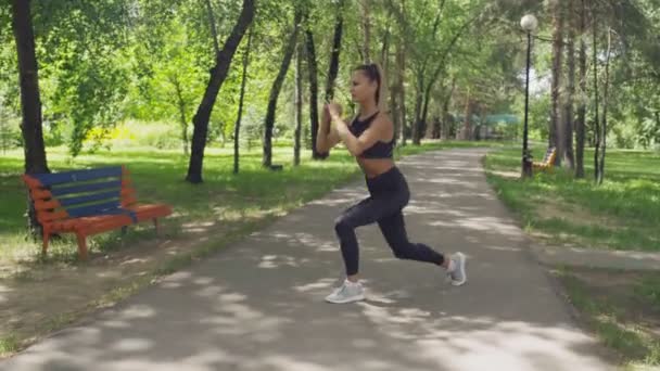 Mujer de fitness haciendo ejercicios de embestidas para los músculos de las piernas entrenamiento — Vídeos de Stock