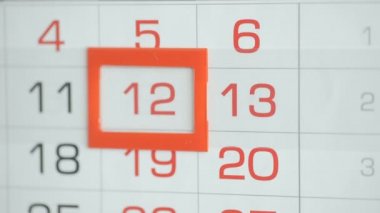 Ofisteki kadınlar duvar takvimindeki tarihi değiştirirler. 12 'den 13' e değiştirir