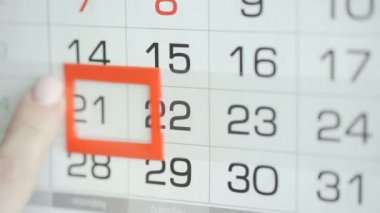 Ofisteki kadınlar duvar takvimindeki tarihi değiştirirler. Değişiklikler 21 'e 22