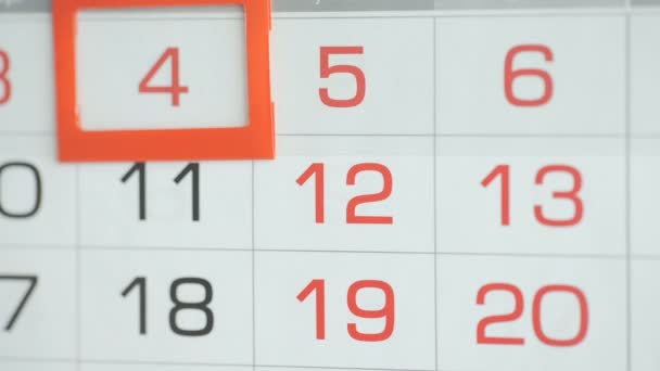 女性のオフィスでの手は、壁のカレンダーで日付を変更します。変更4～5 — ストック動画