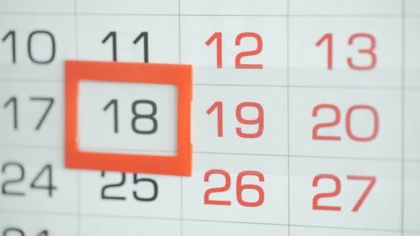 女性のオフィスでの手は、壁のカレンダーで日付を変更します。変更18～19 — ストック動画