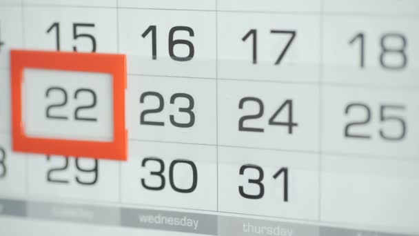 女性のオフィスでの手は、壁のカレンダーで日付を変更します。変更22～23 — ストック動画
