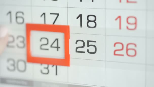Womans hand in office changes date at wall calendar. Changes 24 to 25 — Stock Video