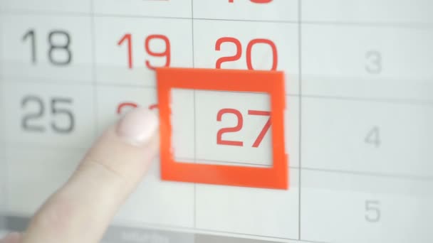 Las mujeres de la mano en la oficina cambia la fecha en el calendario de pared. Cambios 26 a 27 — Vídeo de stock