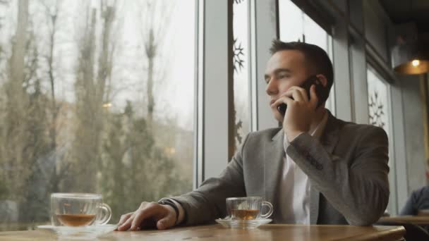 Hombre con teléfono móvil en una cafetería — Vídeos de Stock