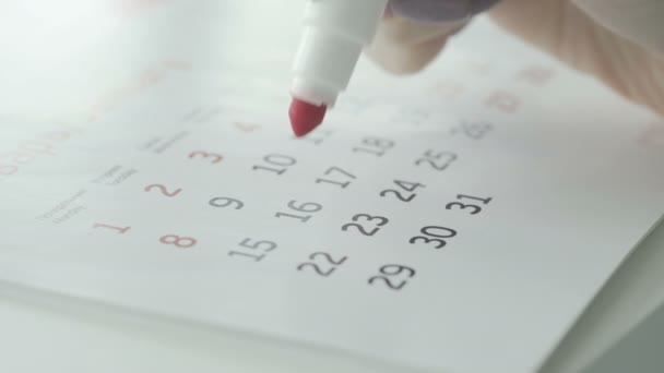 Vrouwelijke handcirkeldag op papieren kalender. 16e dag van de maand — Stockvideo
