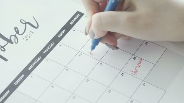 Macro da mão escrevendo um prazo de palavra no calendário sob a data de 11 — Vídeo de Stock