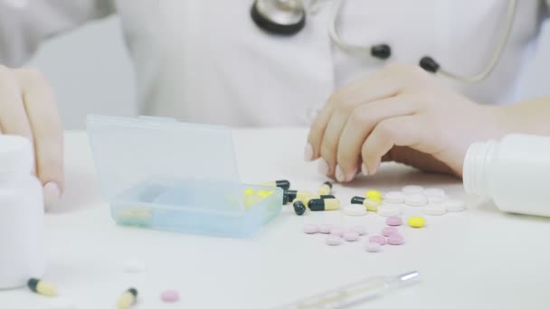 Lékař vloží tobolky a pilulky do krabičky — Stock video