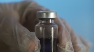 Mavi arka planda ampulden şırıngaya ilaç dolduruluyor