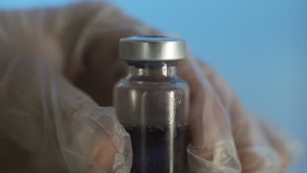 Filling medicine from ampoule into syringe on a blue background — Stock Video