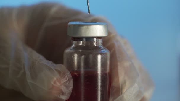 Fylla läkemedel från ampull till spruta ett rött läkemedel — Stockvideo