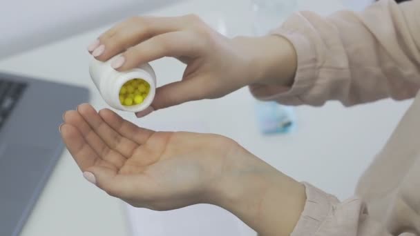 A nő szedi és mutatja tabletták vitaminok vagy gyógyszerek tabletta a kezében tabletta palack — Stock videók