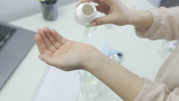 Vrouw giet twee een gele pillen uit de fles op zijn hand — Stockvideo