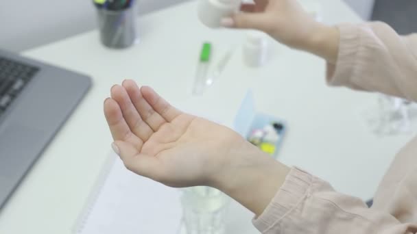 Vrouw giet een gele pillen uit de fles, neem één en water drinken — Stockvideo