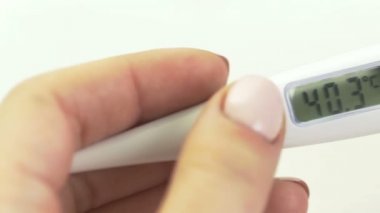 Kadınların elindeki tıbbi dijital termometrenin kaydırak görüntüsü 40.3