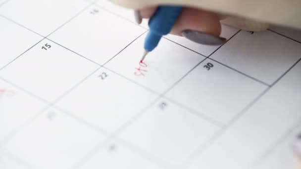 Womans hand writing with red pen on calendar start diet — Stock Video