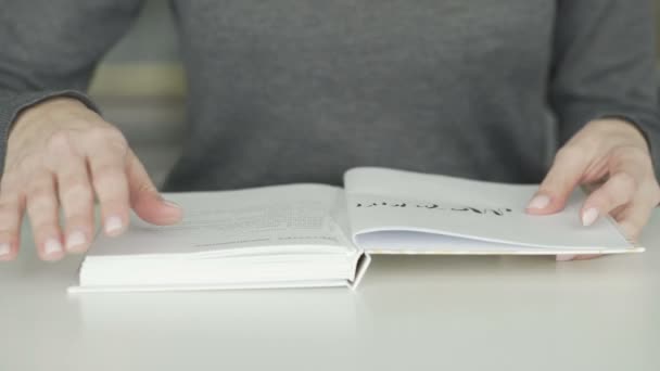 Femme retourne une page tout en lisant un journal — Video