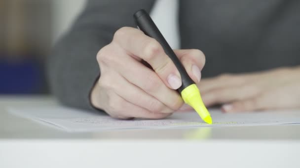 Weibliche Handmarkierung von Text mit gelbem Markierungsstift — Stockvideo
