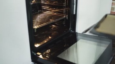 Kadın aşçı mutfakta kruvasan pişiriyor.