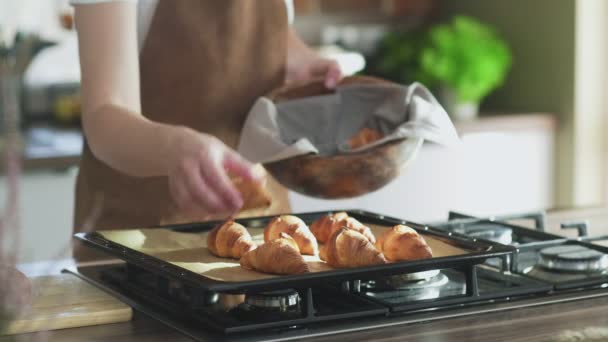 Samice dává vařené croissanty do dřevěné mísy — Stock video