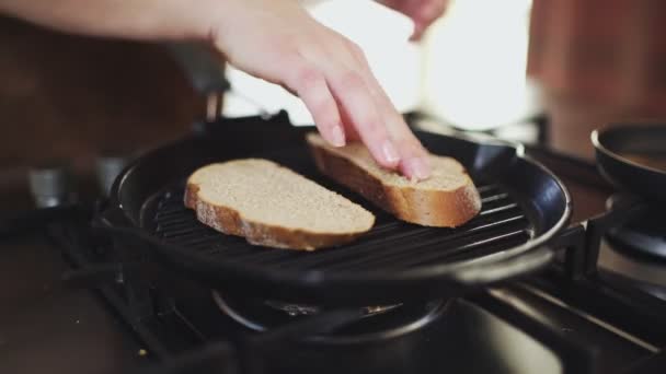 Un primer plano de cuatro rebanadas de baguette se fríen en una sartén para bruschetta italiana. — Vídeo de stock