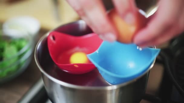 Breaking eggs in saucepan water — Stock Video