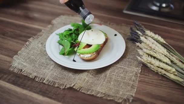 Bruschetta con salmón, aguacate, requesón y huevo escalfado en la mesa — Vídeos de Stock