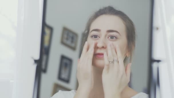 Retrato de una mujer con crema o máscara cosmética en la cara . — Vídeos de Stock