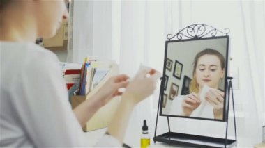 Genç kadın bir yüz maskesi açma. Genç kadının kozmetik maske cilt bakımı için yapması.