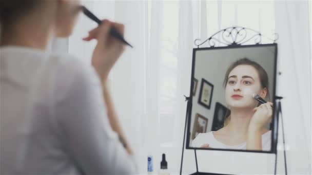 Γυναίκα εφαρμογή καλλυντικών μάσκα στο χώρο μπροστά από τον καθρέφτη — Αρχείο Βίντεο