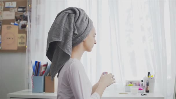 Jovem mulher bonita com a toalha na cabeça aplicando batom em seus lábios — Vídeo de Stock
