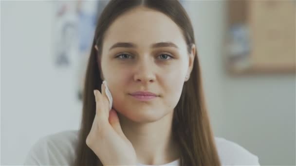 Femme nettoyage visage avec coton pad et regarder la caméra — Video