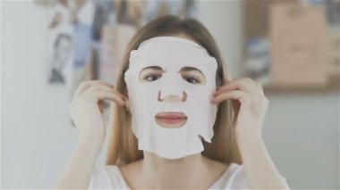 Aynaya bakıyorum ve kozmetik Japon maskesi yüzünde uygulama kadın