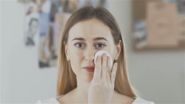 Frumoasa femeie fata de curatare cu tampon de bumbac si uita-te la camera — Videoclip de stoc