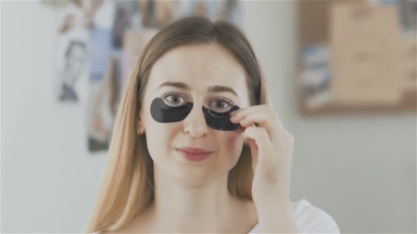 Vrouw opstijgen flarden van een hydraterende masker van collageen. — Stockvideo