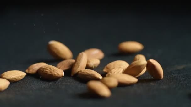 Almonds Falling on a black surface — Stock Video